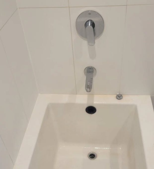 Bathtub before cleaning: yellowed stains and soap scum