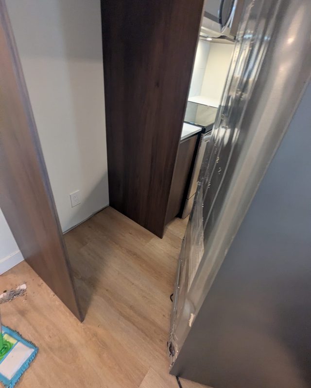 Move-out after: the same spot behind the fridge, floor and walls spotless